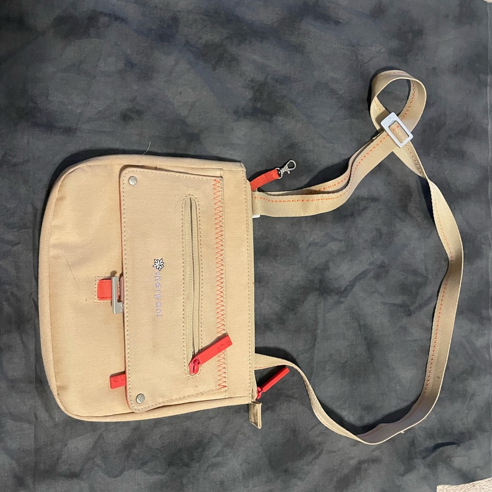 Sherpani tan canvas purse with flower detail and orange